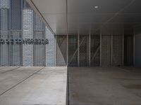 a white building with several steps and large glass panels in the facade is a mosaic that depicts a man