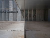 a white building with several steps and large glass panels in the facade is a mosaic that depicts a man