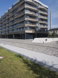 a brick building with glass windows and sidewalk leading to it and a black fire hydrant