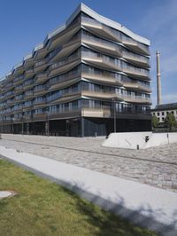 a brick building with glass windows and sidewalk leading to it and a black fire hydrant