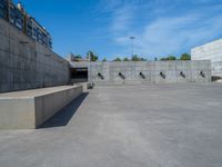 the empty parking lot in front of a wall with apartment buildings on it and a skateboarder on a ramp