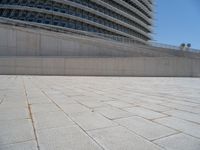 a black fire hydrant is sitting in the concrete area in front of a large building