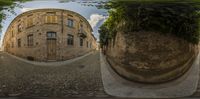 the reflection of a building is shown from below the picture with the circular mirror of the street