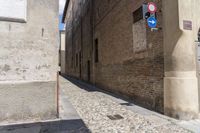 an image of a very narrow street going through some buildings with no cars in front of it