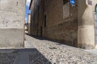 an image of a very narrow street going through some buildings with no cars in front of it