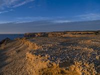 a lone lighthouse is perched on the edge of a cliff in front of the ocean