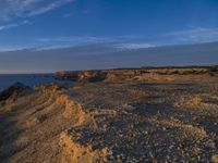 a lone lighthouse is perched on the edge of a cliff in front of the ocean