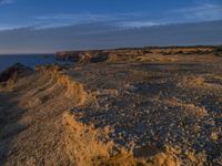 a lone lighthouse is perched on the edge of a cliff in front of the ocean