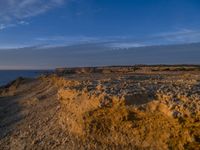 a lone lighthouse is perched on the edge of a cliff in front of the ocean