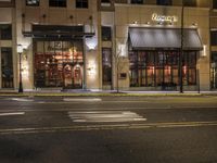 an empty street in the evening with cars parked outside a pizza shop in a city street