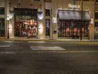 an empty street in the evening with cars parked outside a pizza shop in a city street