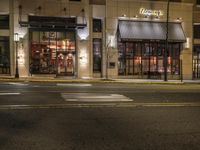 an empty street in the evening with cars parked outside a pizza shop in a city street