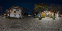 a street with cobblestone street and two buildings in the evening time view from inside