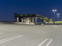 a small parking structure sits in the evening hours on a concrete lot with lots of space for walking or running