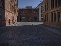 this old city street has cobblestone on it in the evening sun to highlight its surroundings