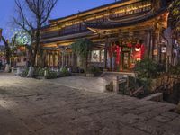 a street scene with a building that has some chinese decorations on it in the evening