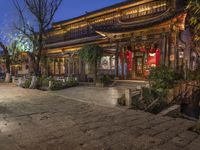 a street scene with a building that has some chinese decorations on it in the evening