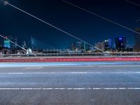 an evening view shows a city and its light trails down the street, with a bike lane to the left