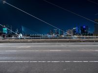 an evening view shows a city and its light trails down the street, with a bike lane to the left