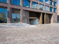 the large building is made of concrete and has metal railings around it, which are made of brick