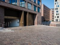 the large building is made of concrete and has metal railings around it, which are made of brick