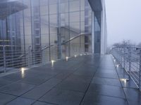 an exterior view of an office building at night, with concrete slabs and stone flooring