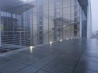 an exterior view of an office building at night, with concrete slabs and stone flooring