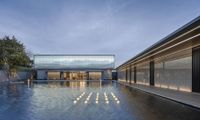 the inside of a swimming pool, with the outside facade lit up by lights reflecting in the water