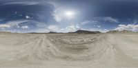 the reflection of a mountain, desert, and sky as seen from a panoramic lens