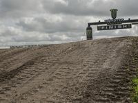 the dirt is being removed near a farm in rural countryside, with a sign warning that tractor tracks are not in place