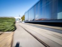 a train travels along a track with trees behind it with motion blurers from moving objects