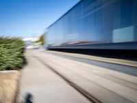 a train travels along a track with trees behind it with motion blurers from moving objects