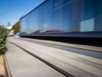 a train travels along a track with trees behind it with motion blurers from moving objects