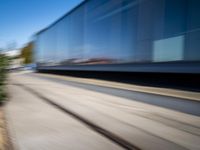 a train travels along a track with trees behind it with motion blurers from moving objects