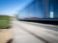 a train travels along a track with trees behind it with motion blurers from moving objects