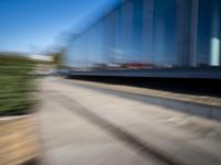 a train travels along a track with trees behind it with motion blurers from moving objects