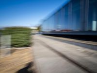 a train travels along a track with trees behind it with motion blurers from moving objects