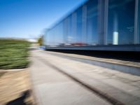 a train travels along a track with trees behind it with motion blurers from moving objects