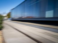 a train travels along a track with trees behind it with motion blurers from moving objects