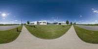 this image is panoramically of a field with a fire hydrant in the foreground