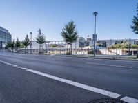 a street is empty on a clear day with a blue sky above it and trees in the foreground