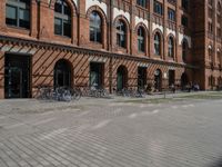 a red brick building with lots of bikes parked on it's side walk in front of it