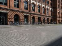 a red brick building with lots of bikes parked on it's side walk in front of it