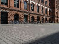 a red brick building with lots of bikes parked on it's side walk in front of it