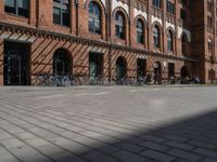 a red brick building with lots of bikes parked on it's side walk in front of it