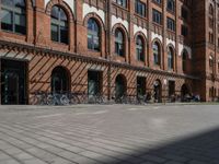 a red brick building with lots of bikes parked on it's side walk in front of it