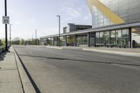 a street corner with an empty street and a bus parked nearby on the road side