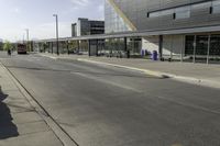 a street corner with an empty street and a bus parked nearby on the road side