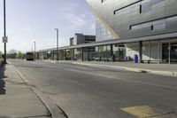 a street corner with an empty street and a bus parked nearby on the road side