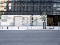 the exterior of an industrial building with concrete parking spaces and metal barriers on both sides